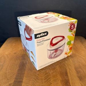 Der Karton des Zyliss Easy Pull E910015 steht auf einem Holzbrett.