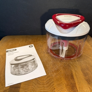 Die Anleitung liegt neben dem Zyliss Easy Pull E910015 auf einem Holzbrett.