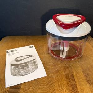 Die Anleitung liegt neben dem Zyliss Easy Pull E910015 auf einem Holzbrett.