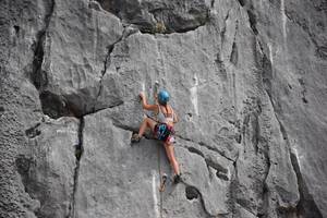 frau mit kletterseil an felsen