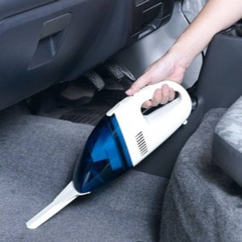 auto wird mit akku-handstaubsauger gereinigt