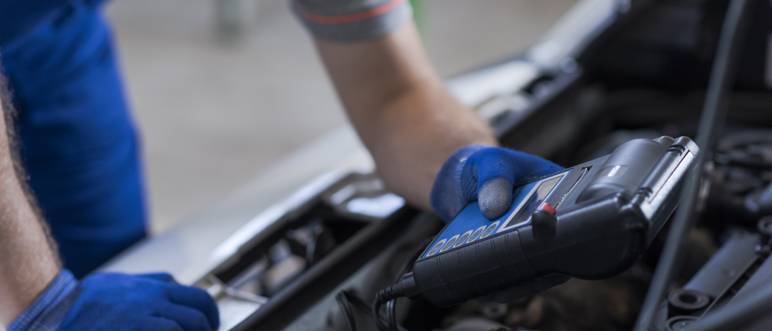 mechaniker misst die batterie ladung