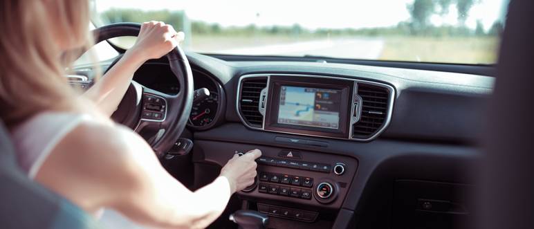 frau faehrt im auto und nutzt das navigationssystem
