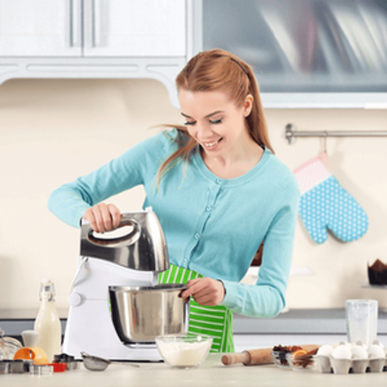 frau bedient kuechenmaschine