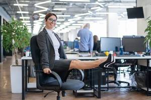 eine frau macht uebungen auf ihrem buerostuhl