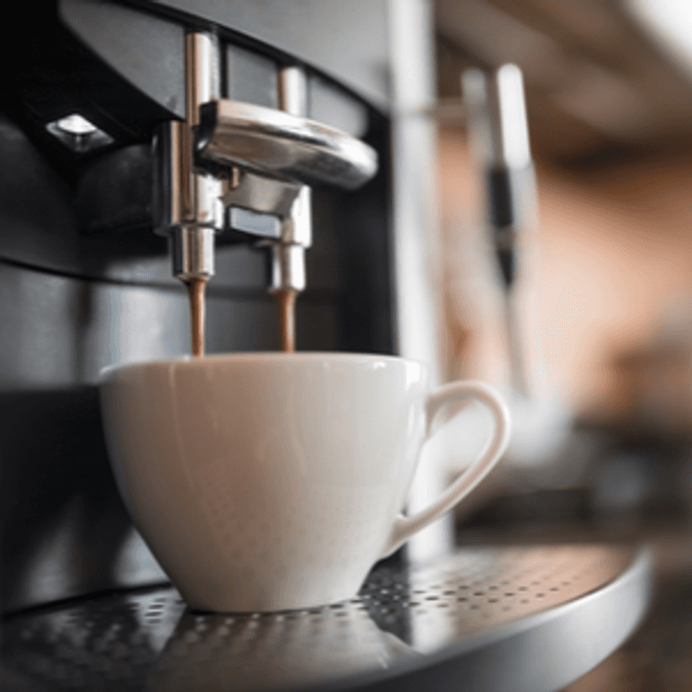 Kaffee, der aus dem Auslass eines DeLonghi-Kaffeevollautomaten in eine Tasse fließt