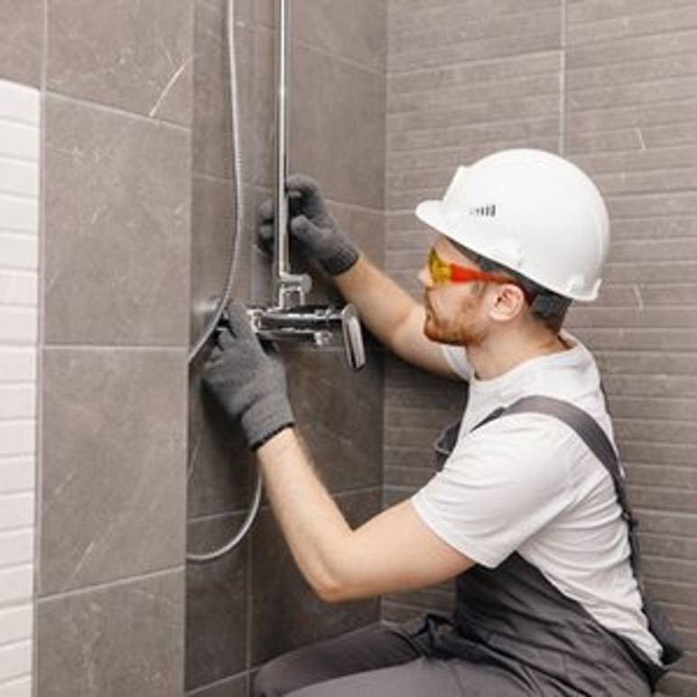 handwerker installiert duschthermostat