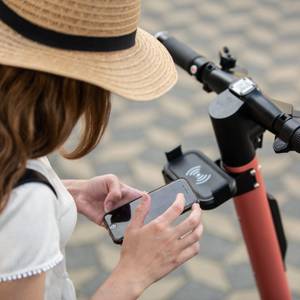 frau mit handy auf e-scooter