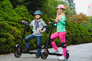 junge und maedchen auf e-scootern