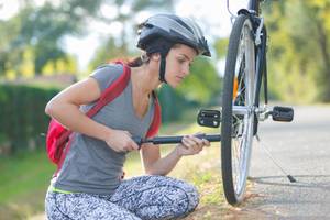 frau pumpt fahrrad auf