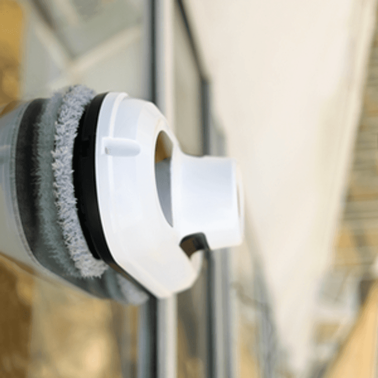 Fensterputzroboter mit runden Reinigungspads an einer Scheibe