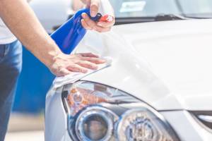 mann wendet flugrostenferner auf auto an