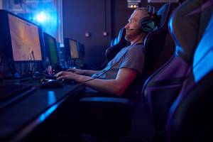 mann auf gaming stuhl mit monitor
