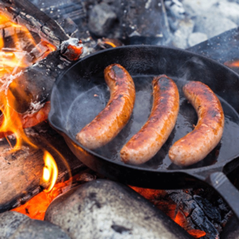Gusseisenpfanne auf Feuer in der Bratwürste liegen