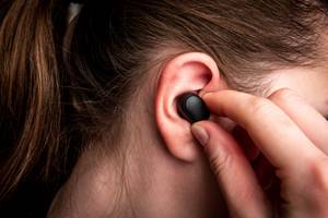 in-ear-kopfhoerer-im-ohr-einer-jungen-frau
