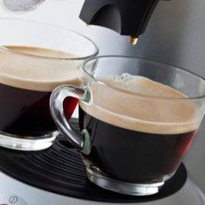 zwei glaeser unter dem auslauf einer kaffeepadmaschine