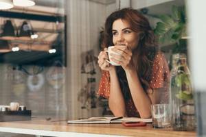 junge huebsche frau trinkt gemuetlich eine tasse kaffee