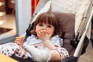 kind isst im kinderwagen