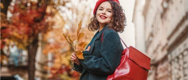 junge frau mit knallrotem lederrucksack