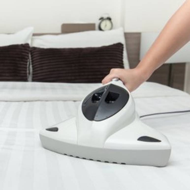 bett wird mit milbensauger abgesaugt