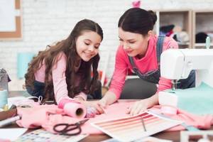 mutter und tochter widmen sich gemeinsam einem naeh-projekt