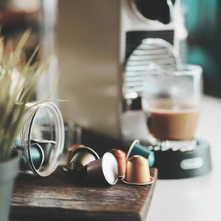 nespresso-maschine mit tasse und kapseln