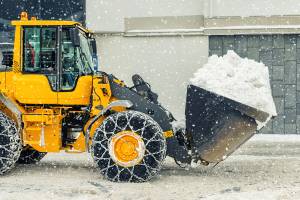 traktor mit schneeketten beim schneeraeumen