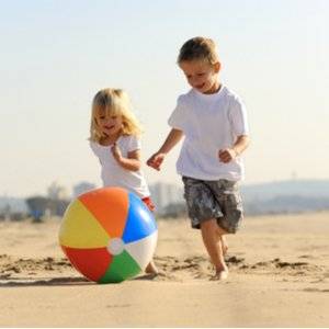 geschwister mit beachball am strand