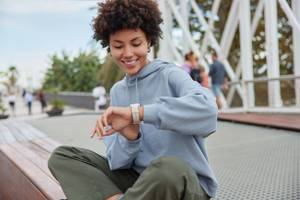 junge-frau-bedient-draussen-ihre-smartwatch-am-handgelenk