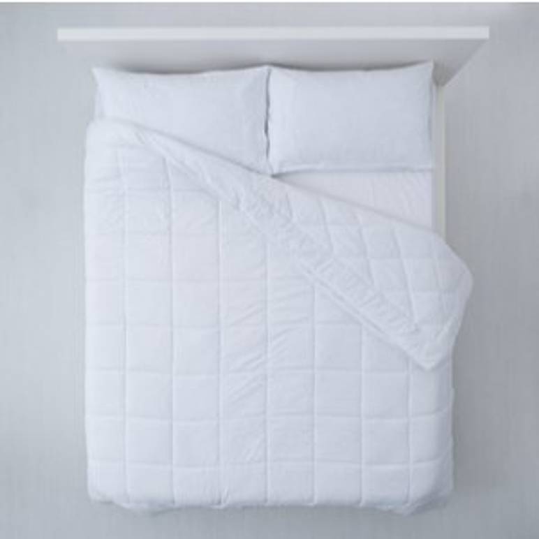 unbezogenes bett mit kissen und sommerdecke