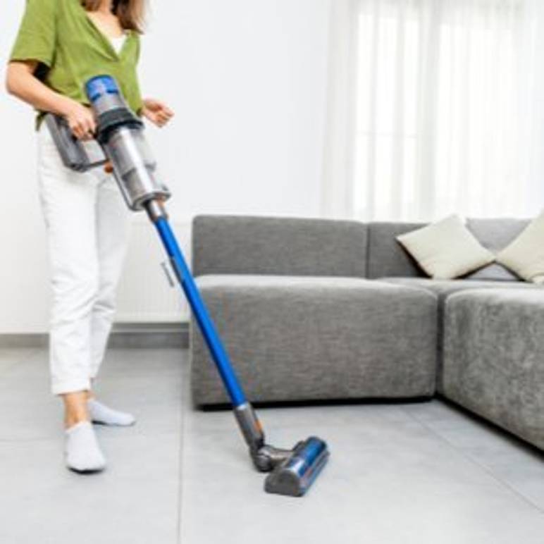 frau saugt boden mit standstaubsauger