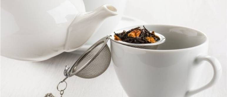 tee-ei mit losem tee in einer weissen tasse
