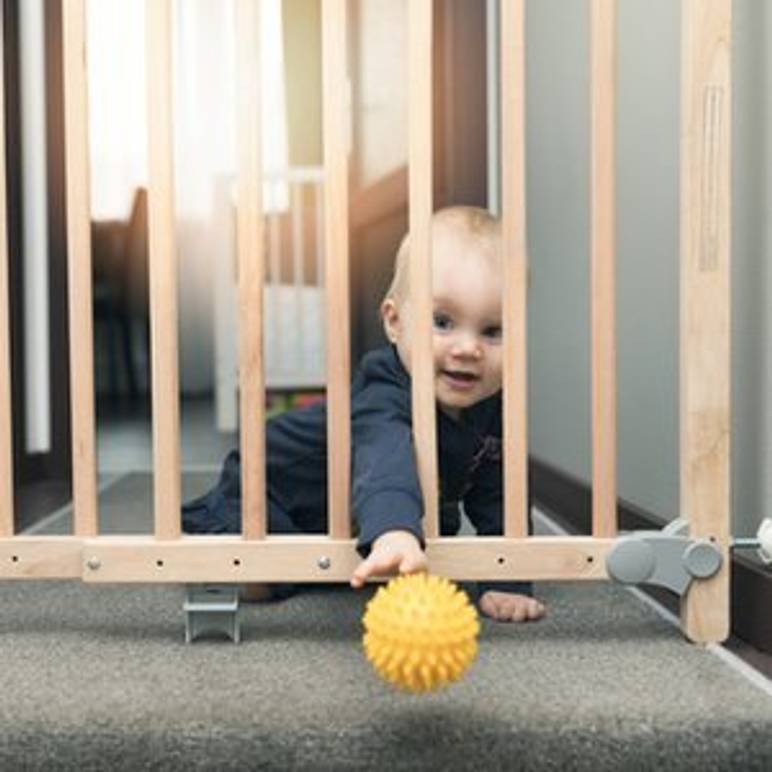 kleinkind an treppe hinter treppenschutzgitter